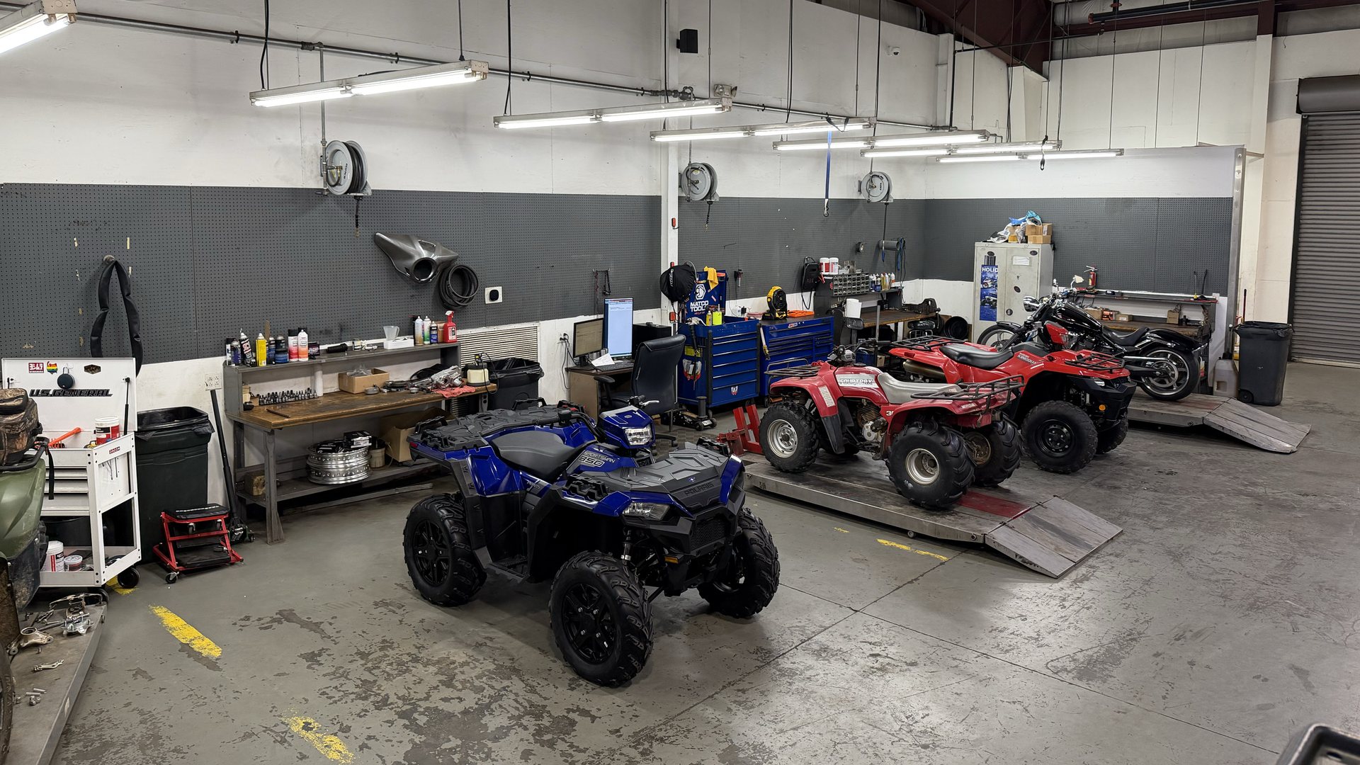 Inside the Dothan Powersports service shop, machines on the lifts