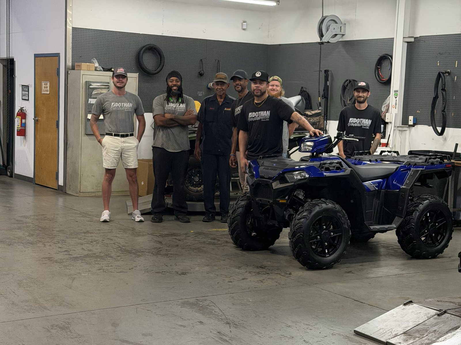 The service team in the shop with a Polaris Sportsman
